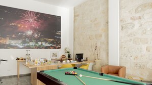 A pool table with a cue stick, a billiards ball rack, and a pool table with a green felt surface. - Apartment Ground Floor Amber (Alcamo)