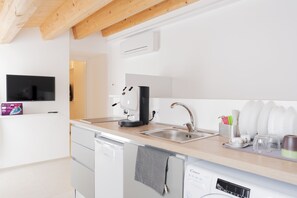 Eine moderne Küche mit Geschirrspüler, Kaffeemaschine und Spüle.