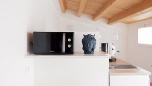A kitchen with a microwave, a decorative bust, and a kettle on the counter. - Sky D'Alcamo Diamond (Alcamo)