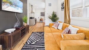 A modern living room with a sofa, a coffee table, and a TV mounted on the wall.