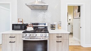 A modern kitchen with a built-in oven, microwave, and gas stove.
