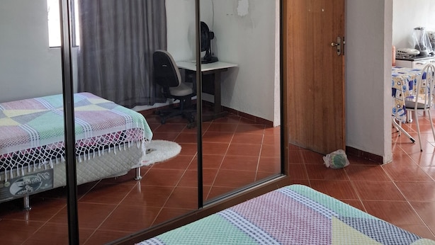 A room with a bed, a desk, a TV, and a door. - Confort Suite 01 (Contagem)