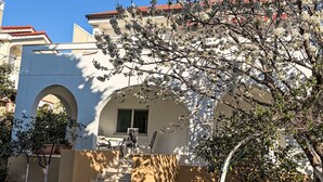 A building with a white facade, red-tiled roof, and a staircase leading to a covered area with outdoor seating. - für 4 Personen ca. 75 m² in Punat, Adriaküs by Interhome (Krk/Punat)