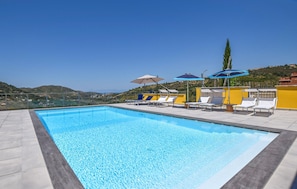 A rooftop swimming pool with lounge chairs and umbrellas, surrounded by a clear view of the landscape. - Nice apartment in Laureana Cilento (Laureana Cilento)