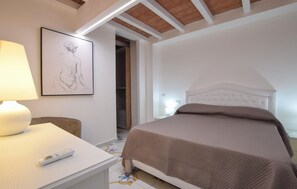 A bedroom with a bed, a bedside table with a lamp, and a framed artwork on the wall. - Stunning apartment in Laureana Cilento with WiFi (Laureana Cilento)