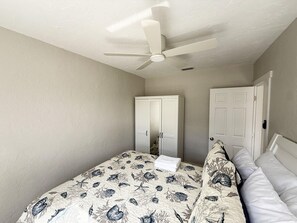 A bedroom with a bed, a ceiling fan, and two doors. - Venice Villas Regina - Beachside - Pool (Venice)