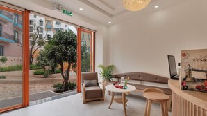 En moderne hotellobby med et siddeområde, et rundt bord og udsigt ud