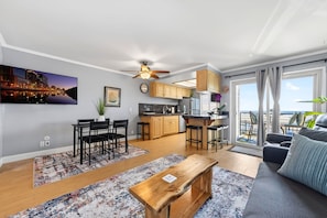 Un salon moderne comprenant un coin repas, une cuisine et un balcon avec vue.