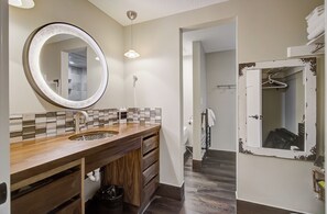 A bathroom with a wooden vanity, a round mirror, and a tiled backsplash. - Shadow Ridge 210 | Pool, Hot Tub, 150 Yards to PCMR (Park City)