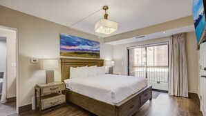Een slaapkamer met een houten bed, twee nachtkastjes met lampen, een groot raam met gordijnen en een schilderij aan de muur.