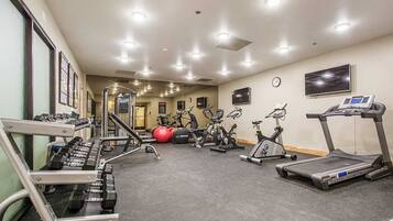 A gym with treadmills, elliptical machines, and weightlifting equipment.