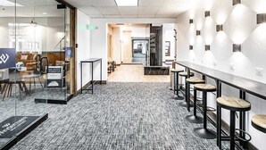 A modern office space with glass walls, a long counter with stools, and a carpeted floor. - Shadow Ridge 210-1 | Modern Hotel-Style Room Steps from PCMR (Park City)