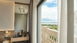 Ein Hotelzimmer mit Balkon, Schreibtisch mit Toilettenartikeln, einem Bett und Blick auf die Landschaft.