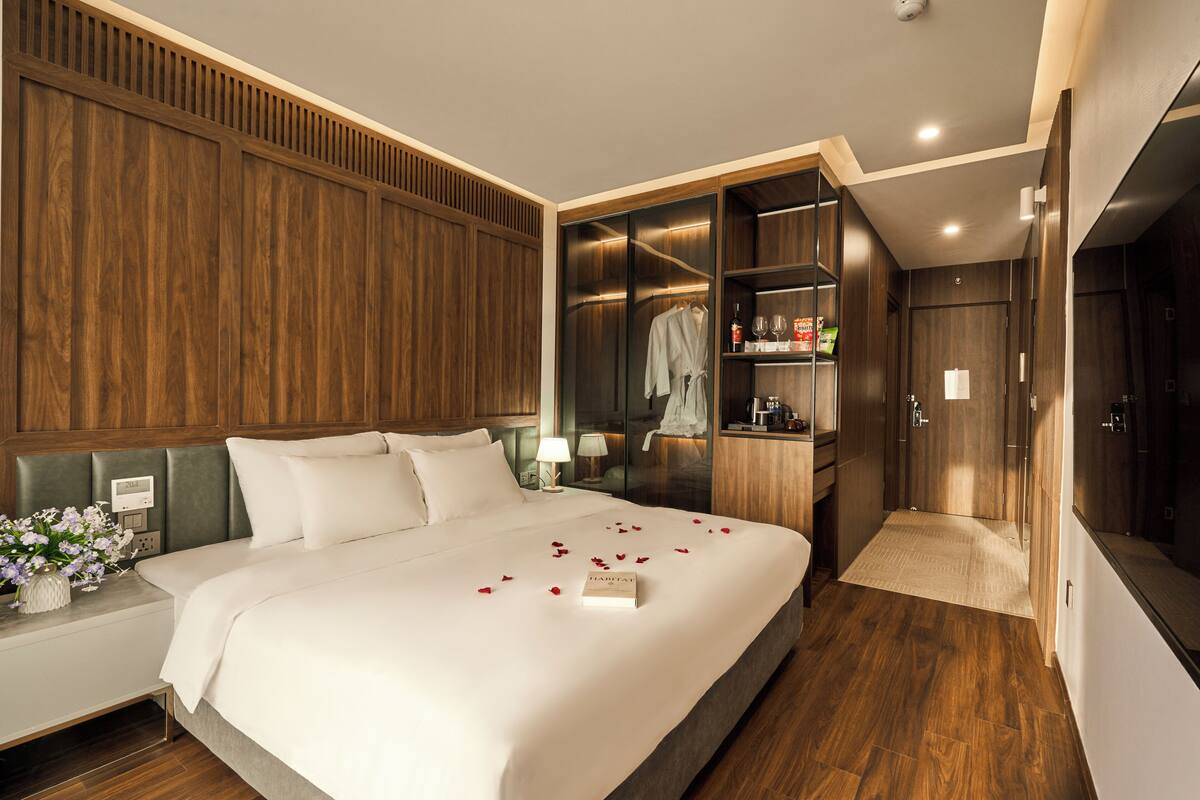 Una habitación de hotel con una cama grande, un vestidor y un baño.