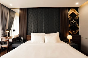 A hotel room with a bed, desk, chair, and a wall with a geometric pattern. - Anstay Marina Hotel Ha Long (Ha Long)
