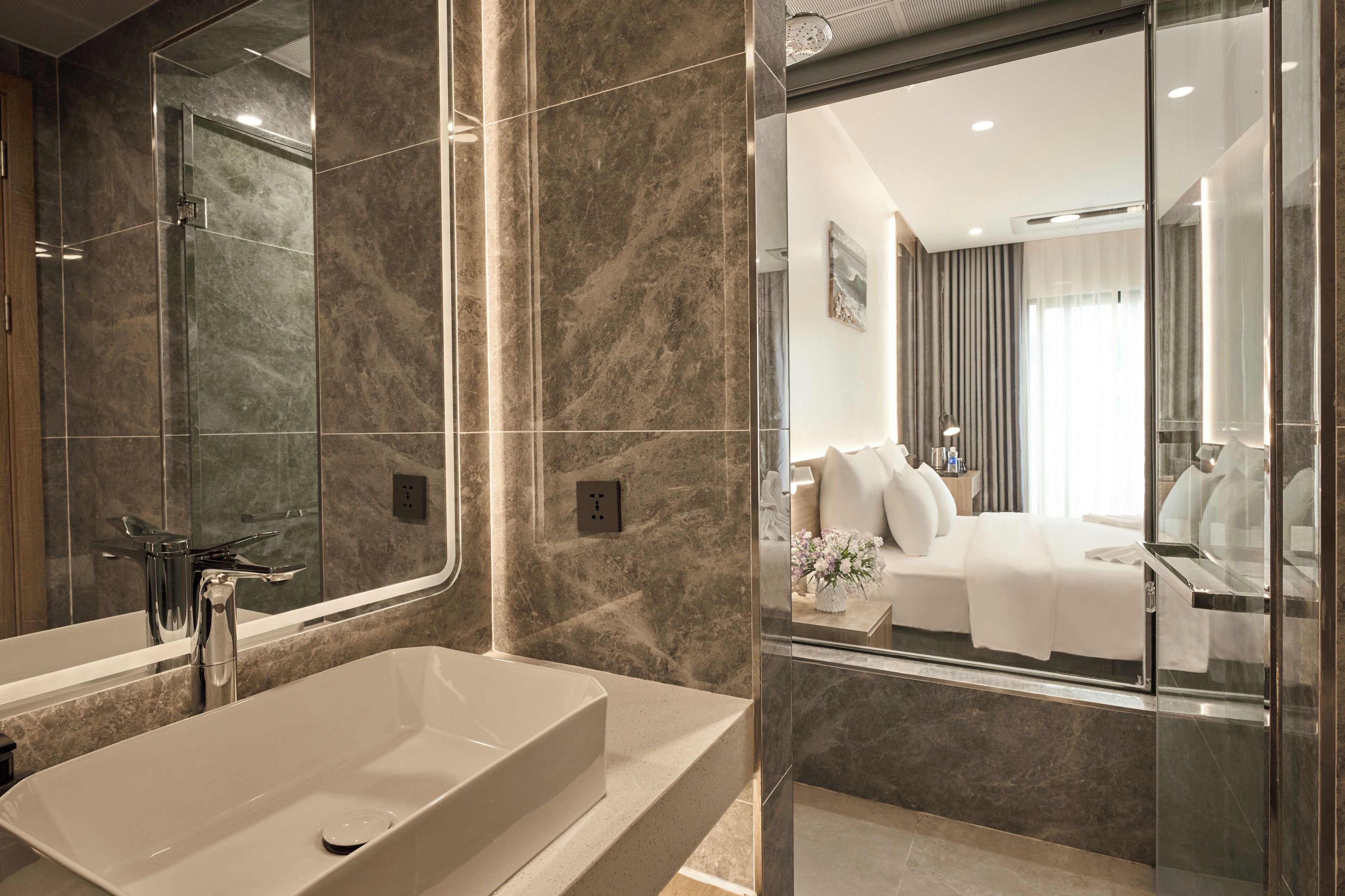 A modern bathroom with a large mirror, a bathtub, and a glass shower enclosure.