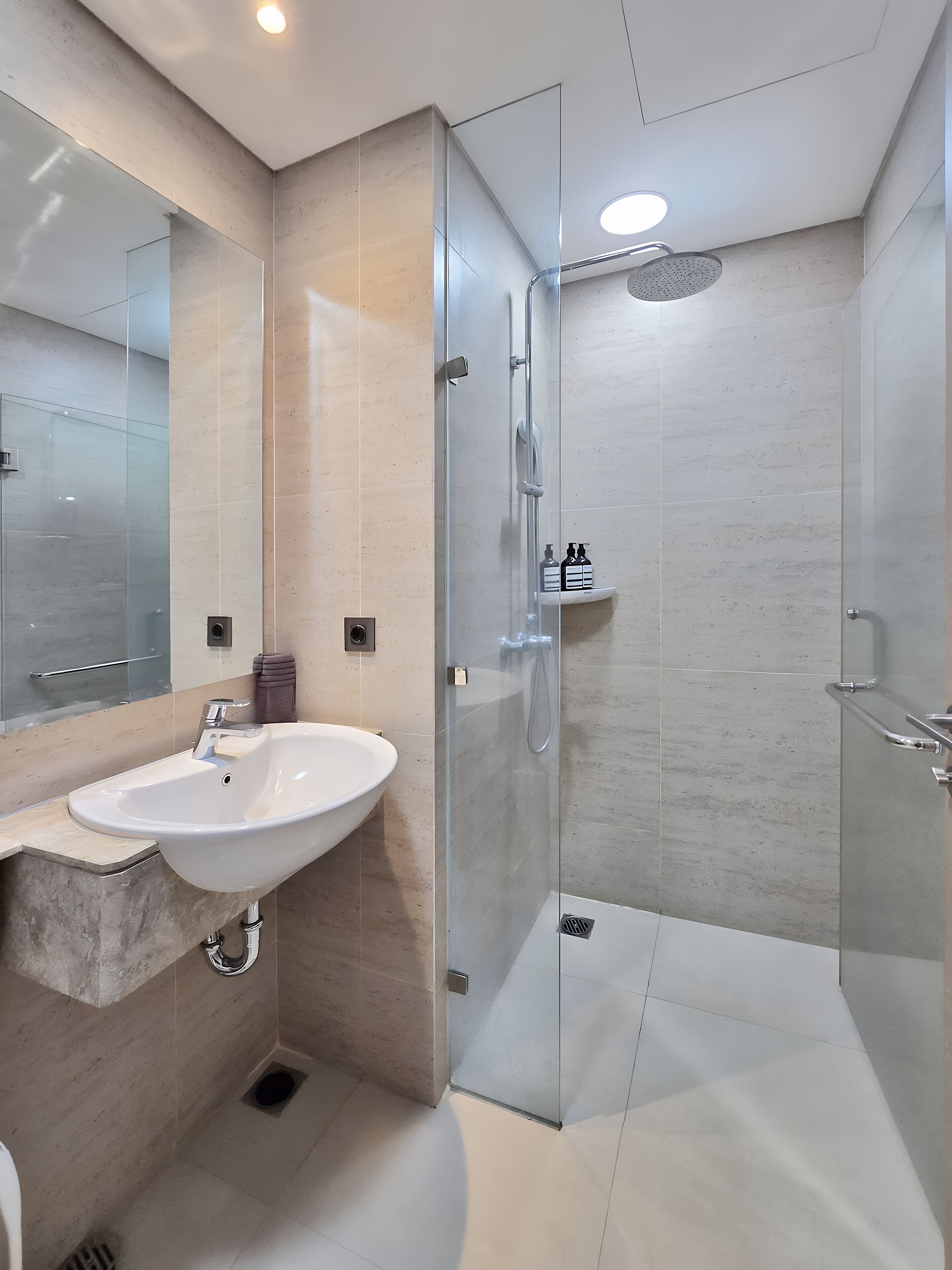 A modern bathroom with a glass-enclosed shower, a white sink, and a marble countertop.