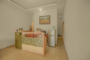 Una cocina pequeña con un mostrador de madera, un refrigerador y un cuadro en la pared.