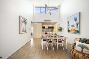 A dining area with a high ceiling, a ceiling fan, and a view into the kitchen. - Elevated Noosa Escape: Heated Pool + Walk to River (Noosa Region)