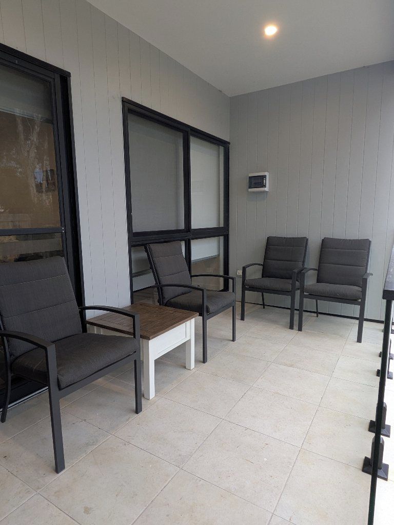 A room with four chairs, a small table, and a large window.