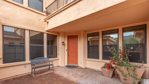 A two-story building with a red door, large windows, a bench, and potted plants. - 30plus Day Stays,5BR Retreat,Near North Mountain (Phoenix)