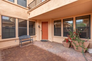 A two-story building with a red door, large windows, a bench, and potted plants. - 30plus Day Stays,5BR Retreat,Near North Mountain (Phoenix)