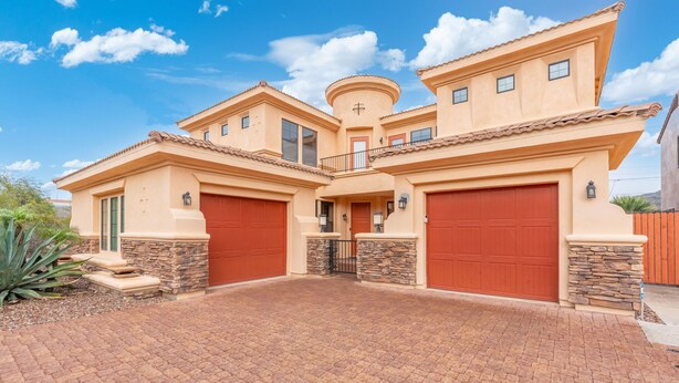 A large, two-story house with a central tower, multiple garage doors, and a paved driveway. - 30plus Day Stays,5BR Retreat,Near North Mountain (Phoenix)