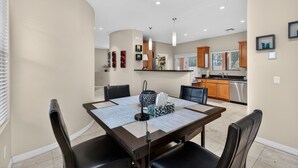 A modern dining area with a rectangular table, black chairs, and a patterned table runner. - 30plus Day Stays,5BR Retreat,Near North Mountain (Phoenix)