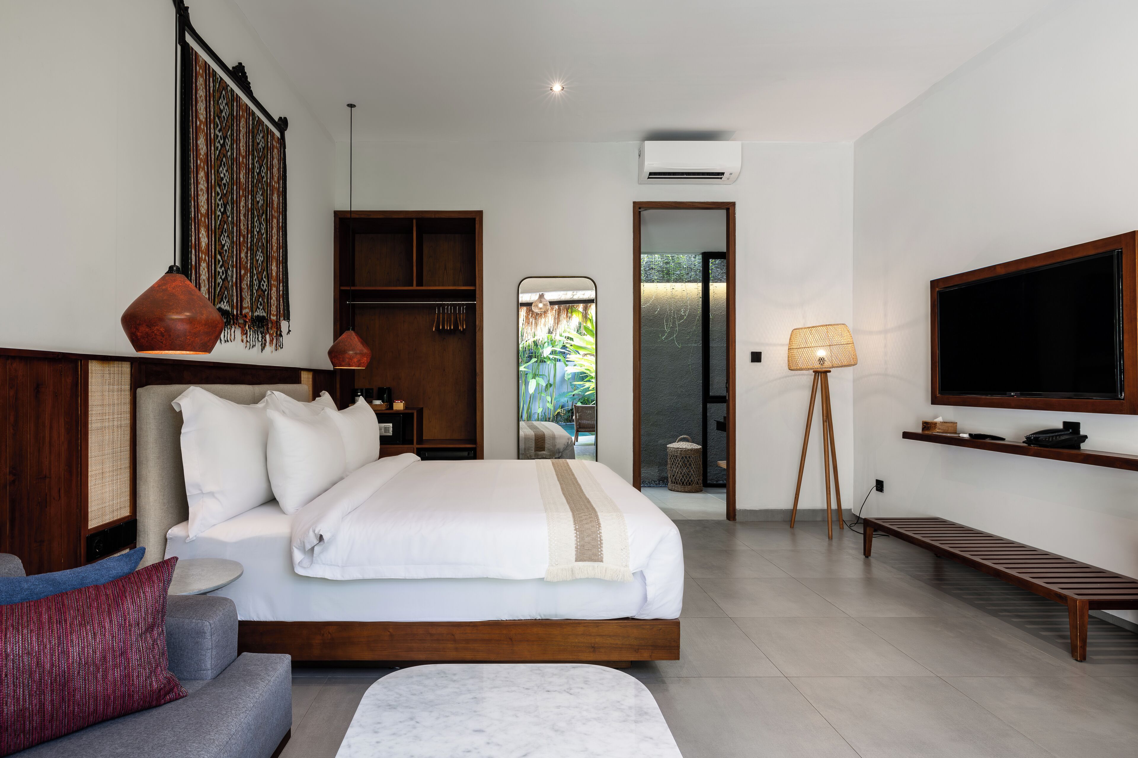 Une chambre moderne avec un grand lit, une télévision, un bureau et une vue sur l’extérieur.