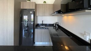 A modern kitchen with a built-in refrigerator, a sink, and a stove. - Marina Cerritos 507 Coastal Retreat – 2BR (Mazatlan)