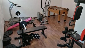 A gym with exercise equipment, a foosball table, and a treadmill. - Wohnung in Börgerwald mit Sauna by Interhome (Surwold)