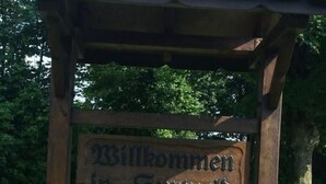 A wooden pergola with a tiled roof and a sign that reads "Willkommen in Sturhold". - Wohnung in Börgerwald mit Sauna by Interhome (Surwold)