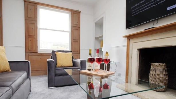 A modern living room with a glass coffee table, leather sofa, and a fireplace. - 3-Schlafzimmer-Wohnung im georgianischen Stil - beste Lage - 7 Gäste by Interhome (Bath)