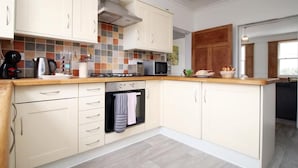 A modern kitchen with white cabinets, a tiled backsplash, and a wooden countertop. - 3-Schlafzimmer-Wohnung im georgianischen Stil - beste Lage - 7 Gäste by Interhome (Bath)