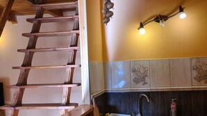 A kitchen with a wooden staircase, a sink, and a wall-mounted light fixture. - mit Wasserblick by Interhome (Chocen)