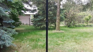 A black metal pole in a grassy area with trees and a building in the background. - mit Wasserblick by Interhome (Chocen)