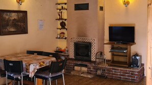 A cozy living room with a fireplace, a television, and a dining area with chairs and a table. - mit Wasserblick by Interhome (Chocen)