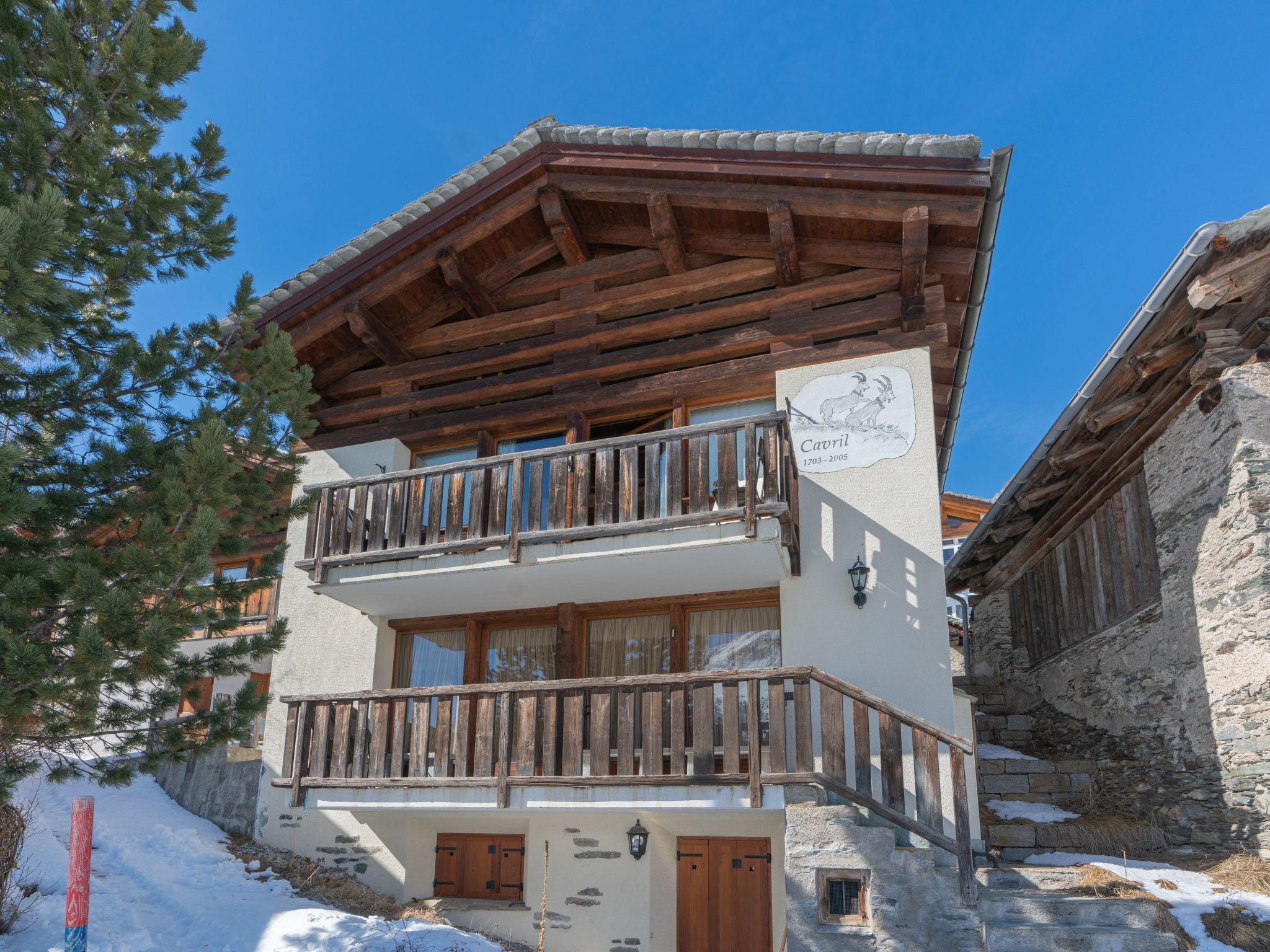 A two-story building with a wooden balcony and stone walls.
