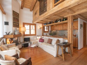 A cozy living room with a fireplace, wooden beams, and a sofa. - Chesa Cavril by Interhome (Maloja)