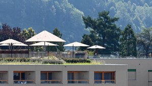 Een hotel met een modern design, met meerdere kamers met grote ramen en een dakbostuin.