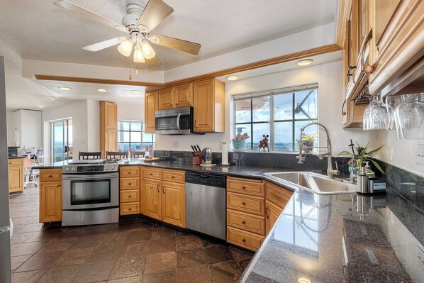 A modern kitchen with wooden cabinets, stainless steel appliances, and a large island. - Home in the Sky! Relax in 4br/2ba Home with Amazing Panoramic SD views. (Spring Valley)