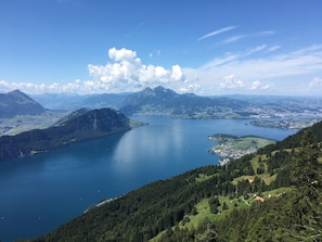 A panoramic view of a mountainous landscape with a large lake, forested areas, and a small town. - Haus Stirnemann/ Wohnung H-3 by Interhome (Weggis)