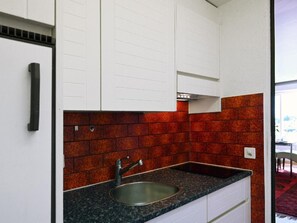 A kitchen with a granite countertop, stainless steel sink, and white cabinetry. - Appartement Alpenblick / F6 by Interhome (Weggis)