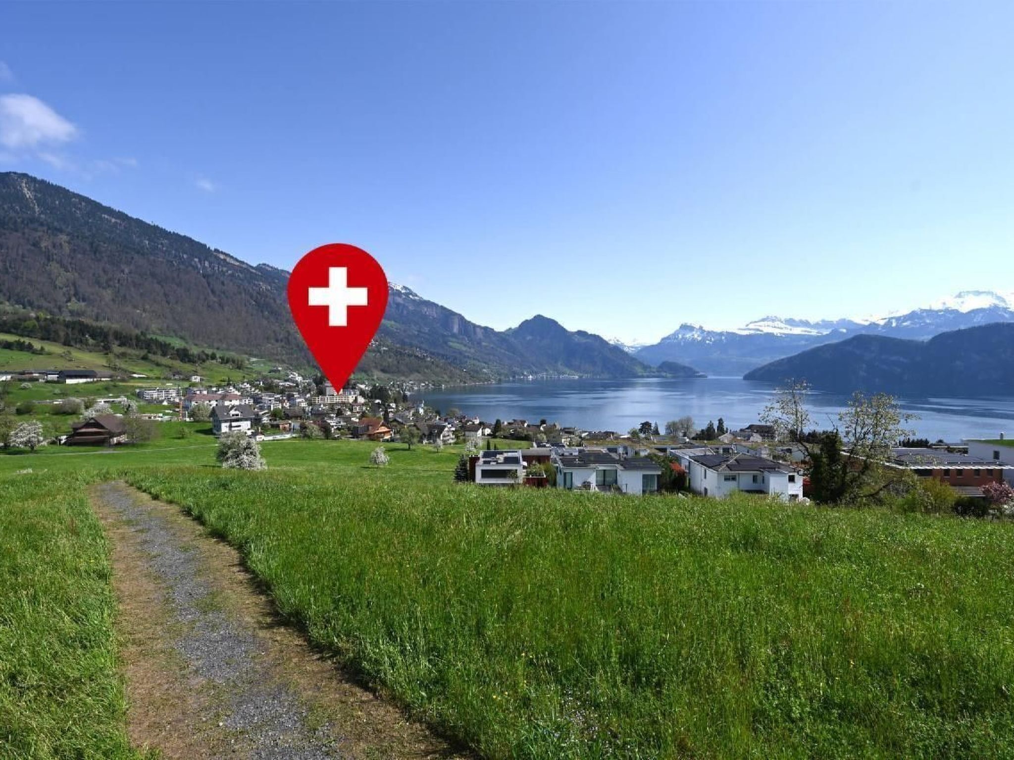 Vista panorámica de un pueblo a orillas del lago, con un marcador rojo que indica una ubicación en Suiza.