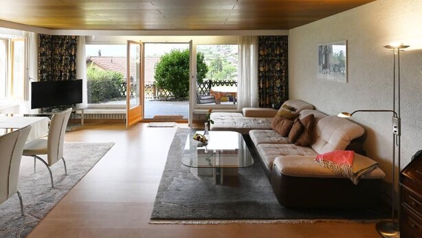 Un salon moderne avec un canapé, une table basse et un téléviseur.