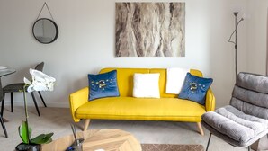 A modern living room with a yellow sofa, a round coffee table, and a potted plant. - Brandneue, zentrale 2-Zimmer-Wohnung für 6 Gäste by Interhome (Preston)