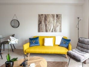A modern living room with a yellow sofa, a round coffee table, and a potted plant. - Brandneue, zentrale 2-Zimmer-Wohnung für 6 Gäste by Interhome (Preston)