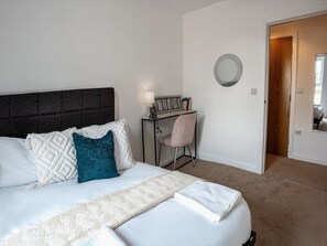 A neatly arranged bedroom with a bed, a desk, and a chair. - Brandneue, zentrale 2-Zimmer-Wohnung für 6 Gäste by Interhome (Preston)
