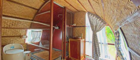 Un intérieur chaleureux, avec des murs en bois, une grande fenêtre, un évier et des toilettes.