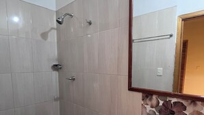 A bathroom with a toilet, sink, shower, and a mirror. - Room 202 with air conditioning (Cúcuta)